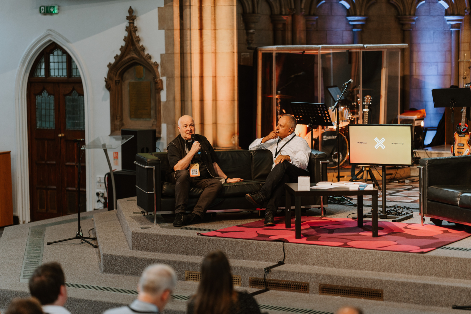 Archbishop of York Stephen Cottrell sits on a black sofa alongside interviewer Christian Selvaratnam