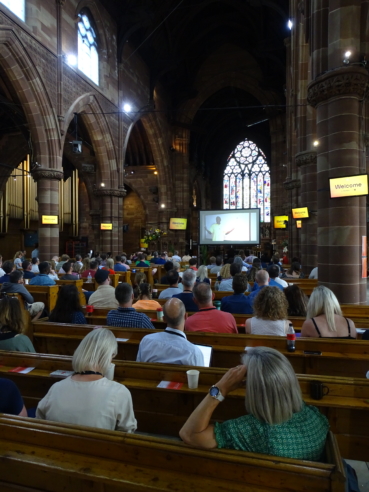 St Martin in the Bull Ring church, filled with delegates watching a video recording of Bishop Oscar Muriu