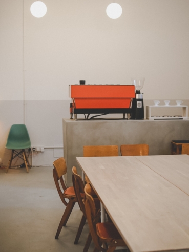 Interior of the ARK coworking space, showing an empty desk area and orange coffee machine